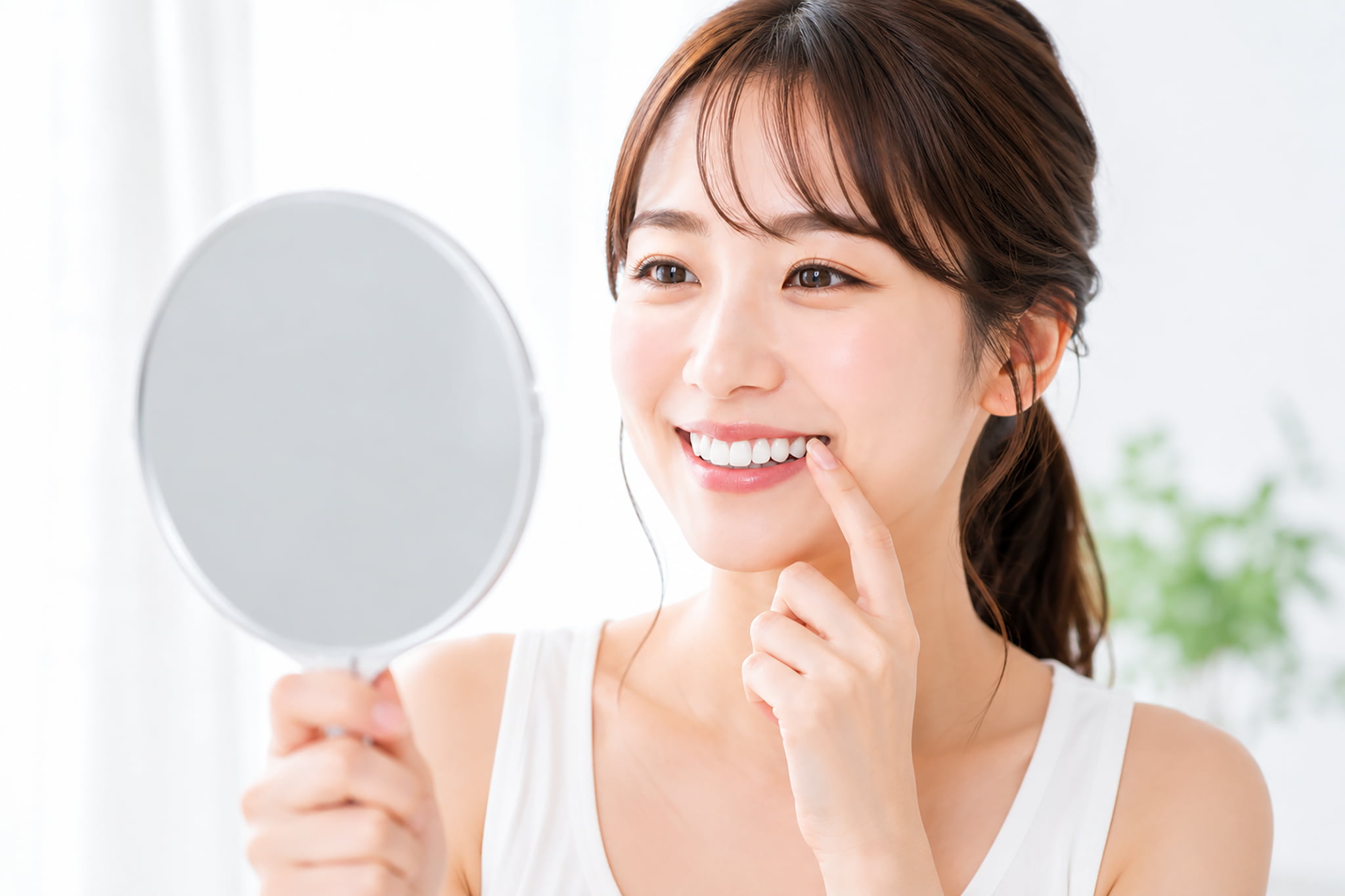 歯茎の健康を鏡で確認する女性
