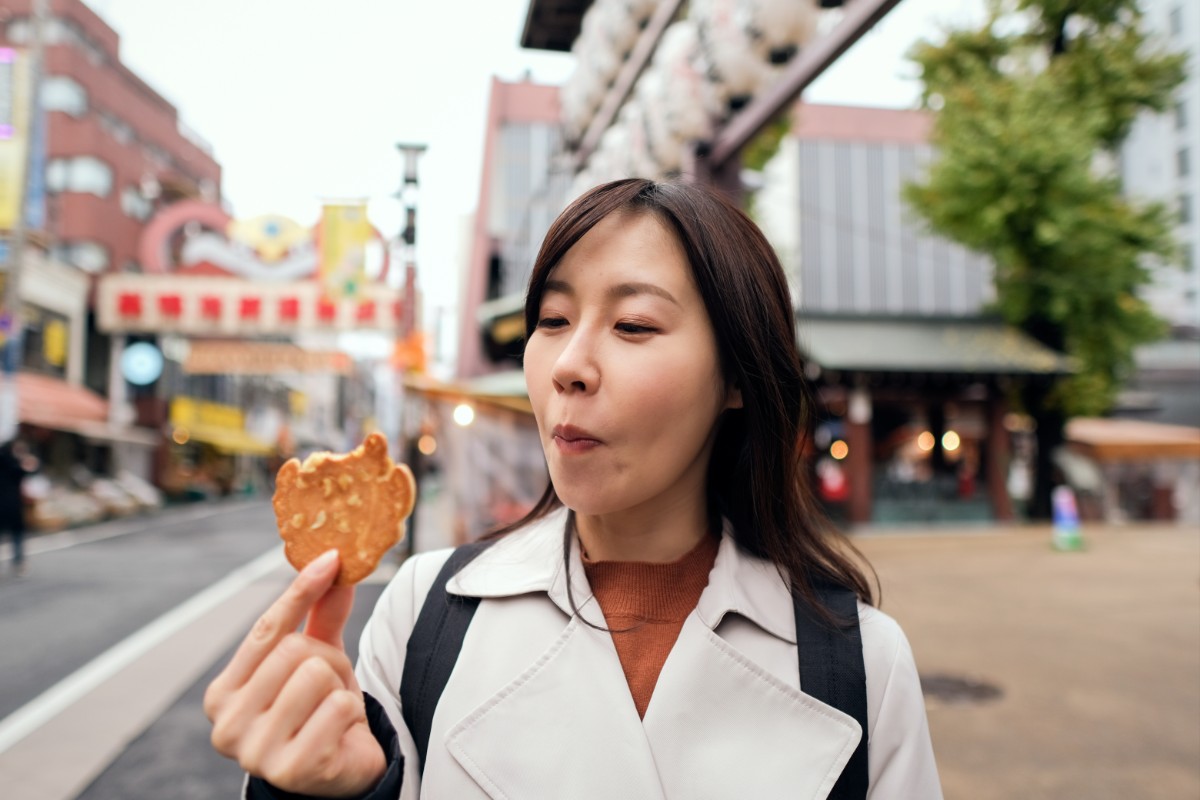 根管治療中に硬いピーナッツ入り煎餅を食べている女性