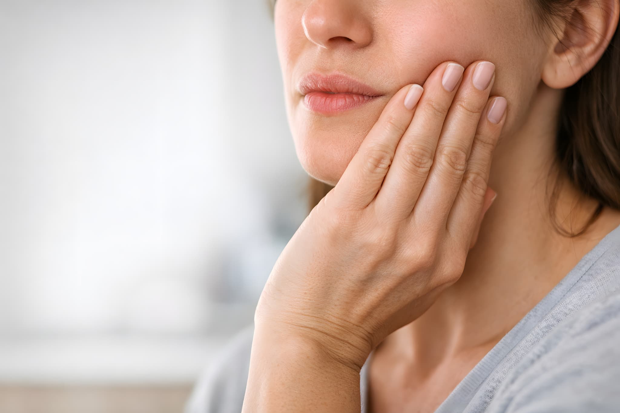 横向きに生えた親知らずは抜歯が必要なのか考える女性